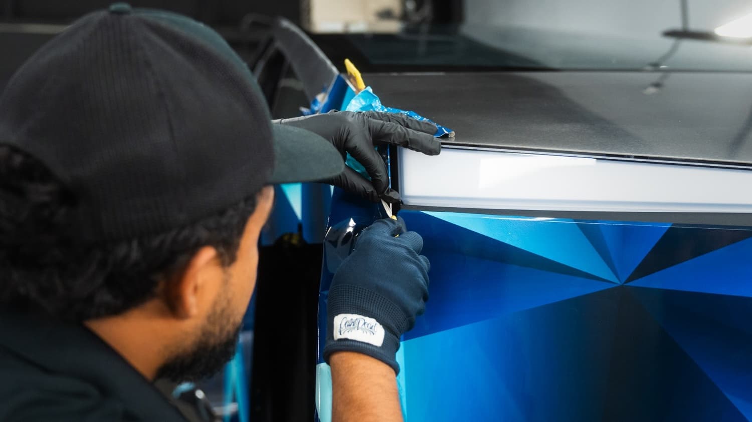 Wrap edge being tucked along the Cybertruck door