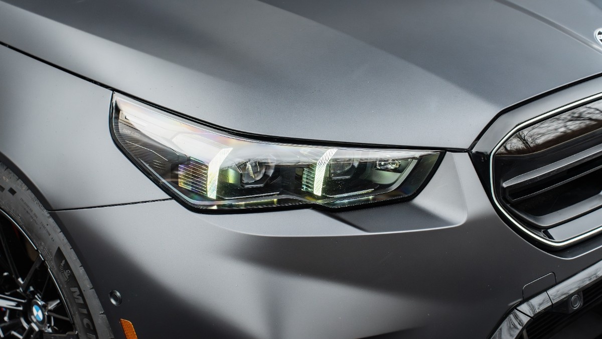 Front-end paint protection film detail on a satin BMW M5